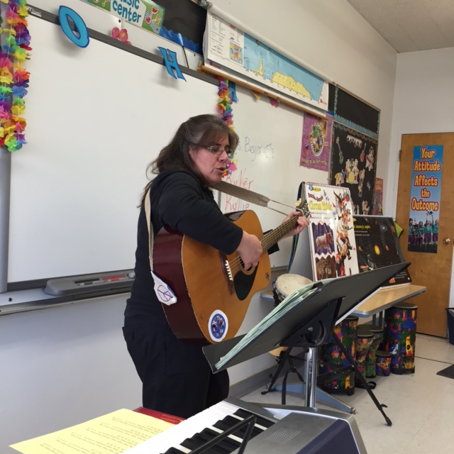 playing lyrics and singing with students.